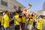 Un grup d’aficionats ‘manteja’ Dai Silva a l’arribada de l’equip a Vila-sana. - JCMC