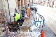 Un operari de l’empresa Agbar reparant ahir la rebentada al carrer Raval del Carme. - MAGDALENA ALTISENT