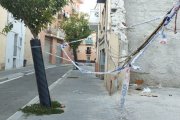 Cables elèctrics penjant al carrer amb cintes policials de protecció. - AV JAUME I