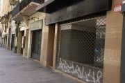 Locals buits, amb pintades al reixat, a l’Eix Comercial. - MAGDALENA ALTISENT