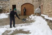 Un home treu la neu de l’entrada de casa seua a Vimbodí i Poblet. - ACN