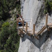 Excursionistes pujant les escales de la paret de Mont-rebei