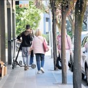 Un usuari amb patinet circulant per una vorera de la Seu. - C.SANS