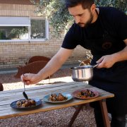 Un cuiner preparant un plat de madonguilles amb sèpia