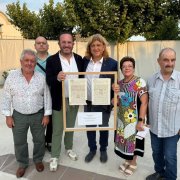 Marc Cerón i David Masot sostenen l’escriptura amb diversos membres de la corporació municipal.