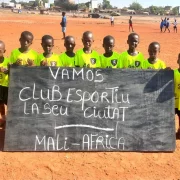 Nens del Centre Djiguiya de Bamako, a Mali, mostren una pancarta de suport al Club Esportiu Ciutat la Seu.
