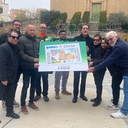 Jordi Castany, alcalde de Alcarràs, i la resta d'impulsors del cupó, posen amb la il·lustració.