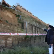 Un veí mira el mur de contenció que va caure a Balaguer. - AMADO FORROLLA