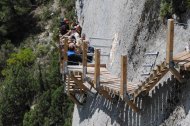 Excursionistes pujant les escales de la paret de Mont-rebei