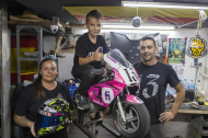 David Delgado, muntat en una de les seues motos, entre els seus pares, Mireia i Chuso.
