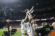 Luka Modric, acompanyat pels seus companys, celebra el gol del triomf sobre una tanca publicitària.