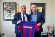 Hansi Flick posa amb Joan Laporta subjectant una samarreta del Barça amb el seu nom imprès.
