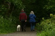 Una pareja de jubilados pasea por el bosque.