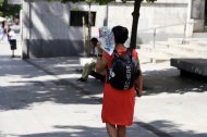 Una vianant es protegeix del sol a Lleida.