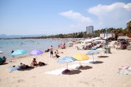 Turistes i banyistes prenent el sol i banyant-se a la platja de Salou