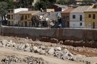 Dos personas pasean junto al barranco del Poyo a su paso por Picanya y donde los daños causado por la inundación son claramente visibles. EFE/Manuel Bruque