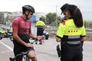 Un ciclista mostra la seva documentació als Mossos d'Esquadra en un control de trànsit.