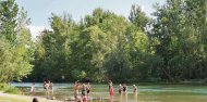 Un grup de banyistes passa la tarda de dijous al curs del riu Segre vora el pont romà de Camarasa.; Array