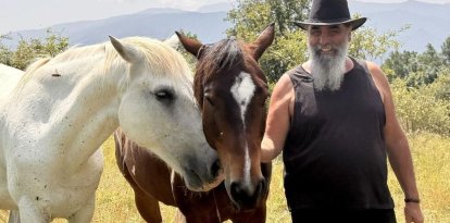 Pere Cases, amb dos dels cavalls retirats que cuida al seu refugi de Montcortès. - MARTA LLUVICH/ACN
