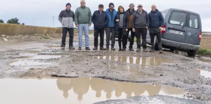 Veïns de Sucs, entre els quals Laura Berenguer, posen al Camí d’Almacelles, ple de clots. - PAU PASCUAL PRAT