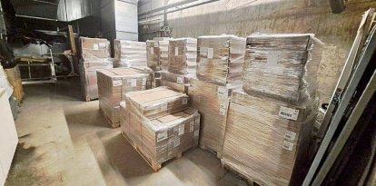 Imatge dels palets amb menjar, llits i estris de lavabo personal en un magatzem. A dalt a la dreta, anvers i revers d’una bossa amb una ració de menjar. - SCD