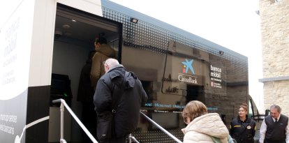 Veïns de Montornès de Segarra entrant a la nova oficina bancària mòbil que un cop al més es desplaçarà al municipi.