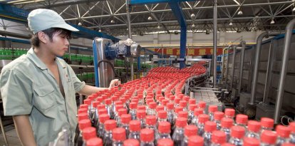 En la imagen de archivo, un trabajador comprueba las botellas de refresco en la línea de control de calidad de la embotelladora de Hangzhou, China.