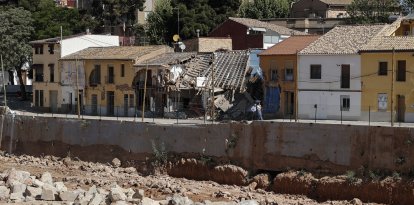 Dos personas pasean junto al barranco del Poyo a su paso por Picanya y donde los daños causado por la inundación son claramente visibles. EFE/Manuel Bruque