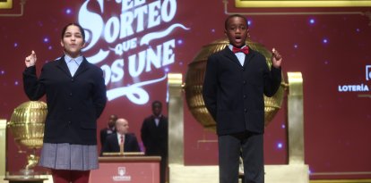 Dos niños del Colegio de San Ildefonso, cantan el 70048 segundo premio de la Lotería de Navidad.
