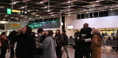 Passatgers desconcertats a l’estació de Sants miren les pantalles que informen de la sortida, arribada o cancel·lació de trens. - ACN