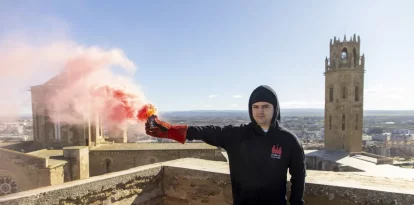 Un dels participants encén una bengala al Castell del Rei. - JORDI ECHEVARRIA