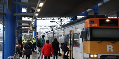 Passatgers pugen a un comboi de Rodalies a l’estació de Lleida-Pirineus. - AMADO FORROLLA