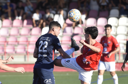 Ángel Fernández, jugador de l’Atlètic Lleida, refusa una pilota de cap davant d’Álex Sánchez.