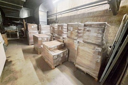 Imatge dels palets amb menjar, llits i estris de lavabo personal en un magatzem. A dalt a la dreta, anvers i revers d’una bossa amb una ració de menjar. - SCD