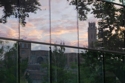 La Seu Vella reflectida en una de les parets laterals del Palau de Vidre, durant la posta de sol