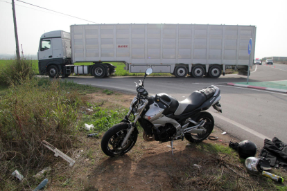 Estat en el qual va quedar la moto i, al fons, el camió implicat.
