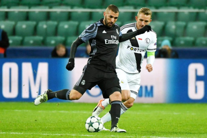 Karim Benzema y Jakub Rzezniczak en un lance del partido disputado en un estadio totalmente vacío. 