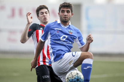 Un jugador del Lleida B controla la bimba davant de la pressió d’un rival.