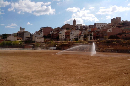 Una vista recent del camp de l’Albagés, amb el poble al fons, aviat amb gespa.