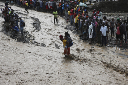 Diverses persones intenten travessar el riu La Digue, a Haití.