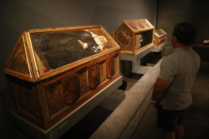 Un visitant contemplant les tres caixes sepulcrals del Museu de Lleida reclamades per Aragó.