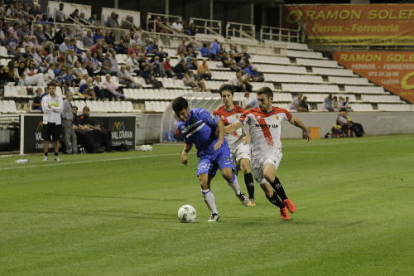 Cristian Fernández protegeix la pilota davant de dos rivals.