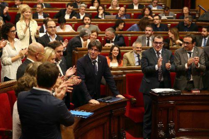 Els diputats de Junts pel Sí aplaudeixen Puigdemont després del seu discurs d’obertura mentre la resta s’estan asseguts.