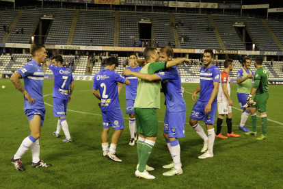 Els jugadors del Lleida s’abracen després del partit per celebrar la victòria davant l’Hospitalet amb les grades de Lateral al fons quasi buides.