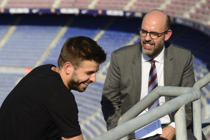 El central del Barça Gerard Piqué i el periodista de RAC1 Jordi Basté, al Camp Nou.