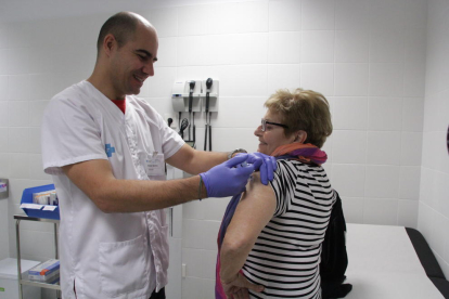 Un infermer vacuna contra la grip una dona aquest dilluns al CAP Onze de Setembre.