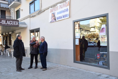 El alcalde de Organyà y dos vecinos, ayer, bajo una de las pancartas colgadas en el municipio para recaudar fondos.