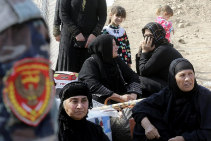 Dones de Mossul esperen retrobar-se amb els seus familiars desplaçats al camp de Khazir.