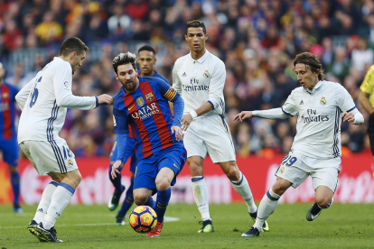 Leo Messi, que no va estar lluny de la seua millor versió, intenta controlar una pilota envoltat pels madridistes Kovacevic, Cristiano Ronaldo i Modric.