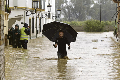 Un home camina entre les cases inundades a la barriada Doña Ana de la localitat malaguenya de Cártama per les fortes pluges.